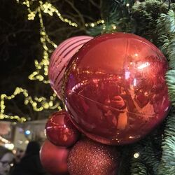 Christbaumkugeln und Tannengrün vor dem Sternenhimmel über dem Buttermarkt